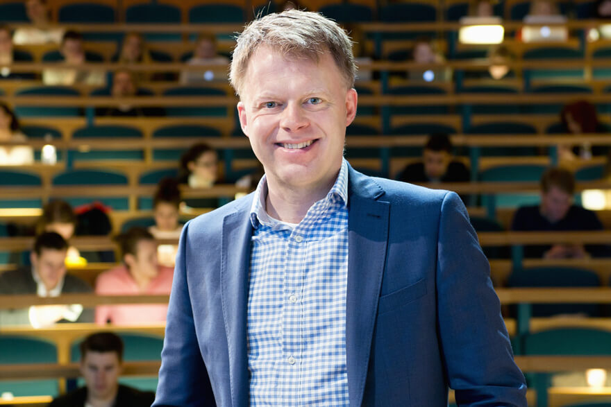 Anders Parment håller en föreläsning om framtidens arbetsmarknad och generation z. Han står på en scen framför en suddig publik.