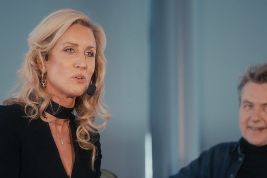 Ami Hemviken föreläser på en scen med en grön bakgrund, med Fredrik Skavlan i publiken. Hon är känd för sin filosofi "Det är inte tanken som räknas."