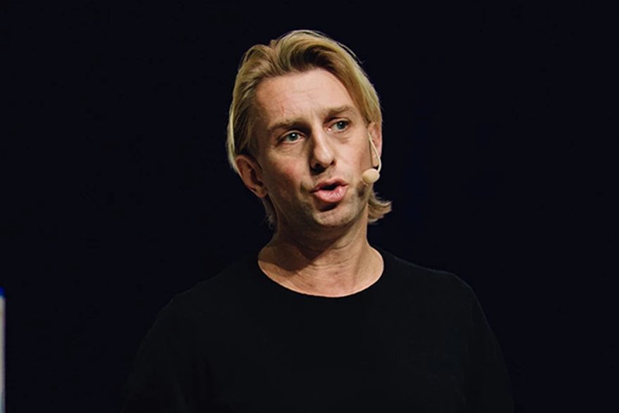Anders Hansen föreläser engagerat om hjärnan, fysisk aktivitet och psykisk hälsa på scen med svart bakgrund.